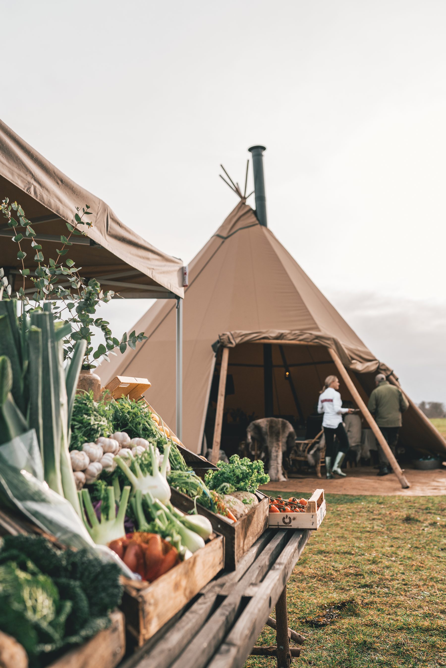 Grøntsagsbod foran en tipi ved en markedsdag