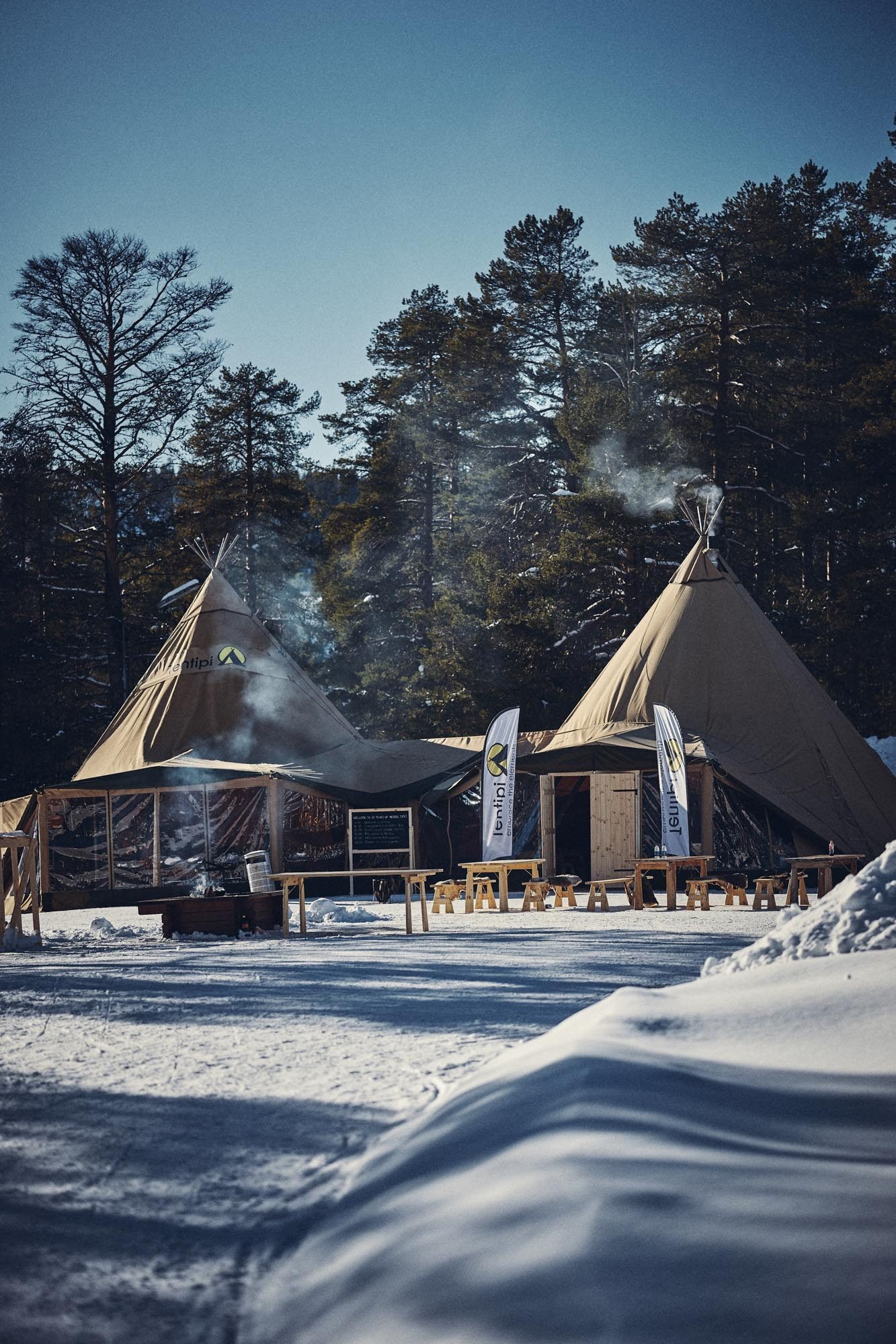 To tipier i sne ved skumring med røg fra skorstenene